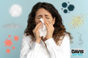 a woman from Camden County sneezing surrounded by indoor air contaminants
